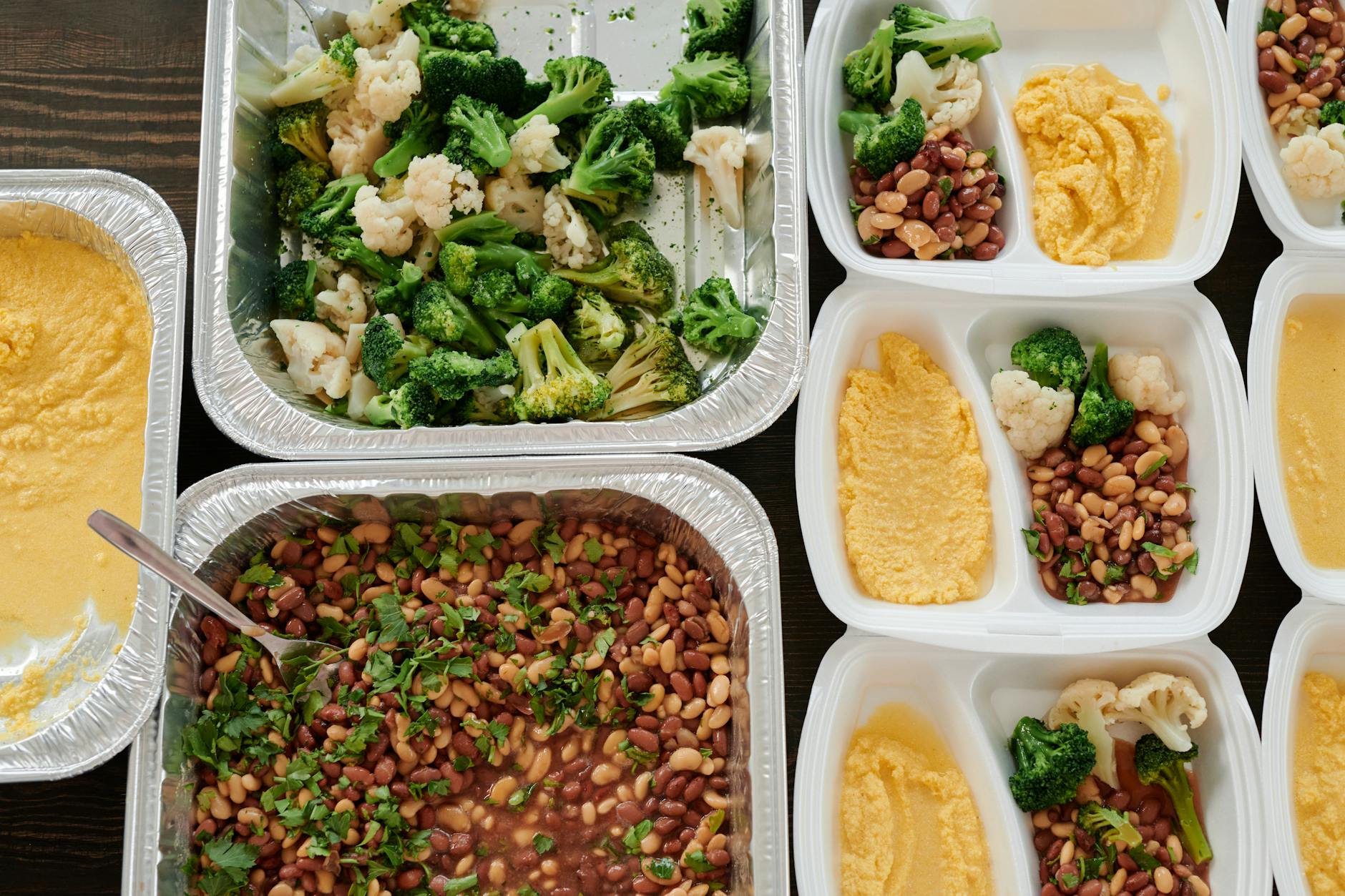 Healthy meal prep with broccoli, beans, and polenta in containers.
