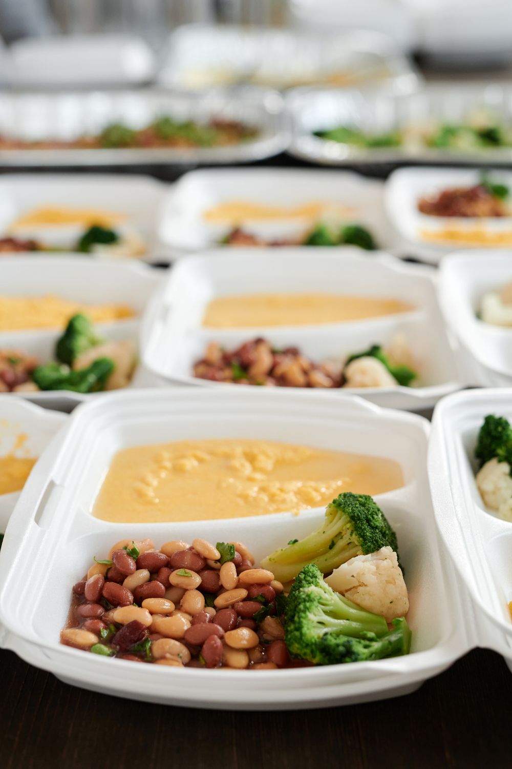 Prepared lunch boxes with vegetables beans and sauce