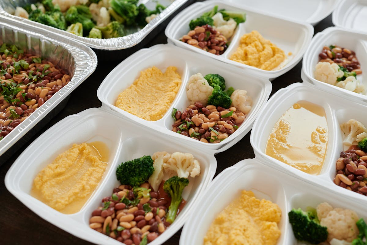 meal prep containers with healthy food alongside high protein low calorie ranch dressing