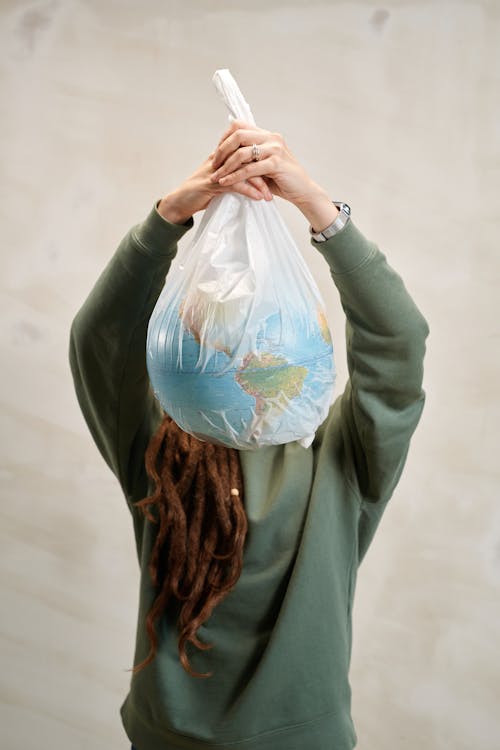 A Person Holding a Globe in a Plastic