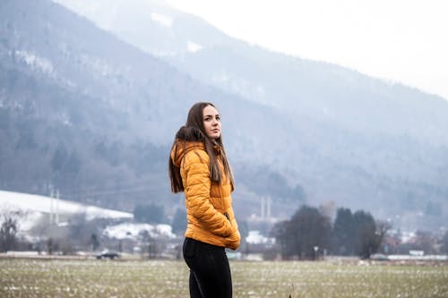 Photo of a Woman Wearing a Yellow Puffer Jacket