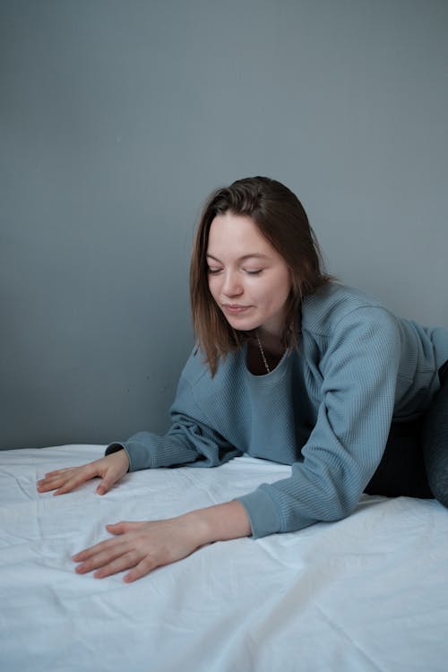 Young woman in casual clothes lying on bed