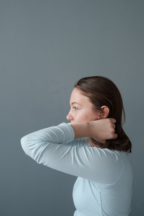 Side View of a Woman Fixing Her Hair