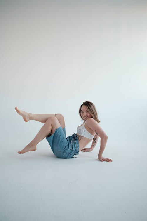 Cheerful woman in bra lying in studio