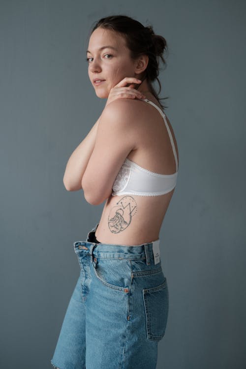 Slim woman in bra standing in studio