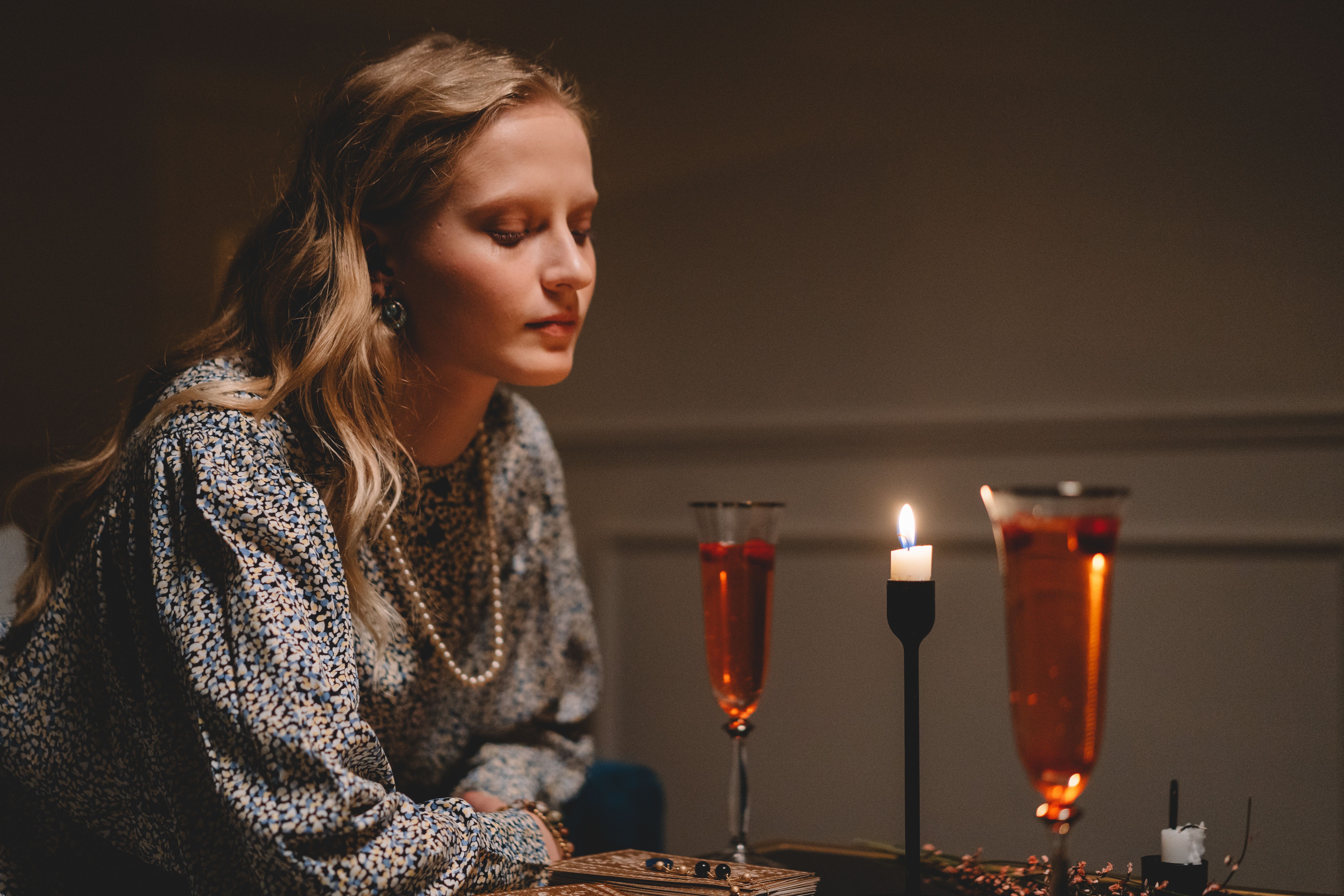 A Woman in Floral Dress Sitting at the Table wih Wine Glasses and a Candle  Light  Free Stock Photo