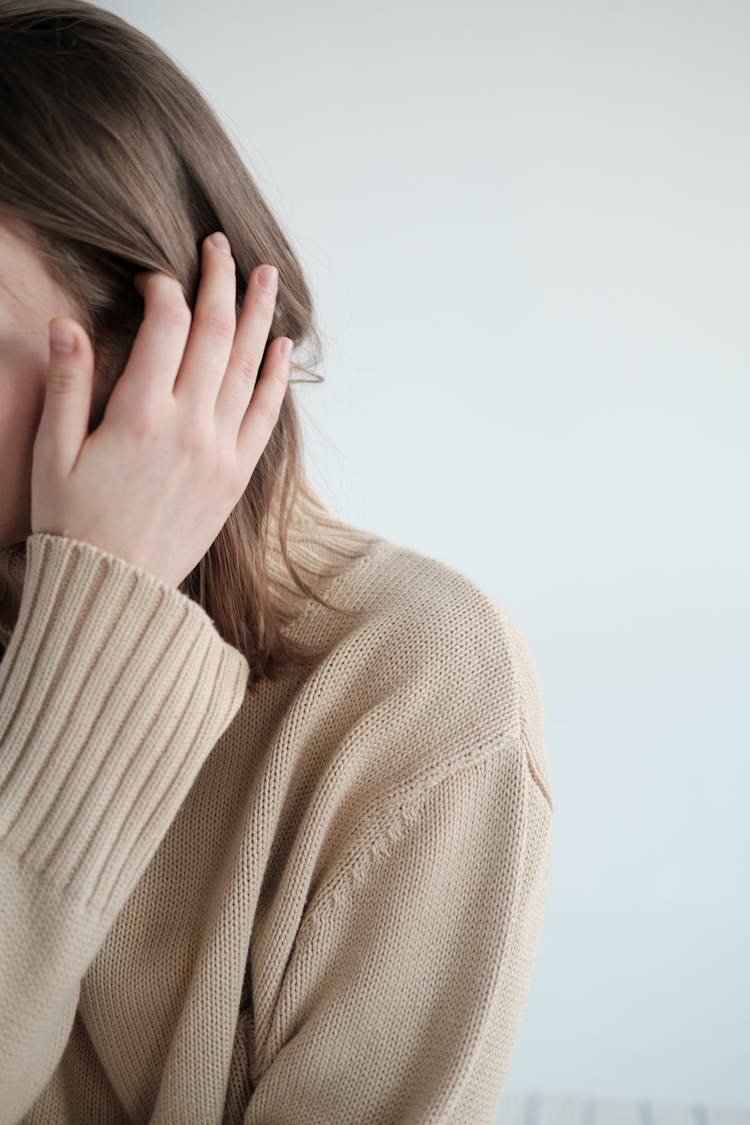 Young Woman In Sweater Touching Hair