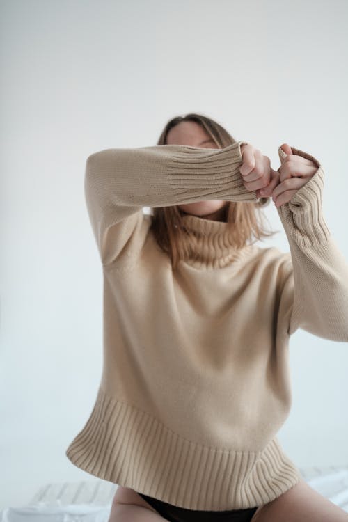 Free Woman in sweater and panties hiding face behind arms Stock Photo