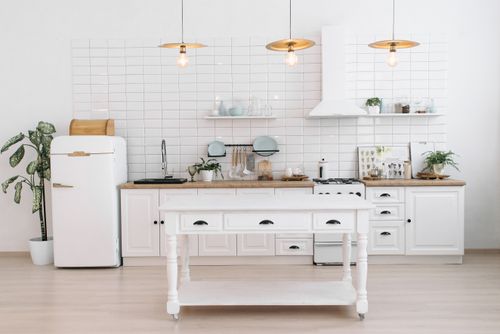 Free A bright, minimalist kitchen with vintage appliances, plants, and pendant lights. Stock Photo