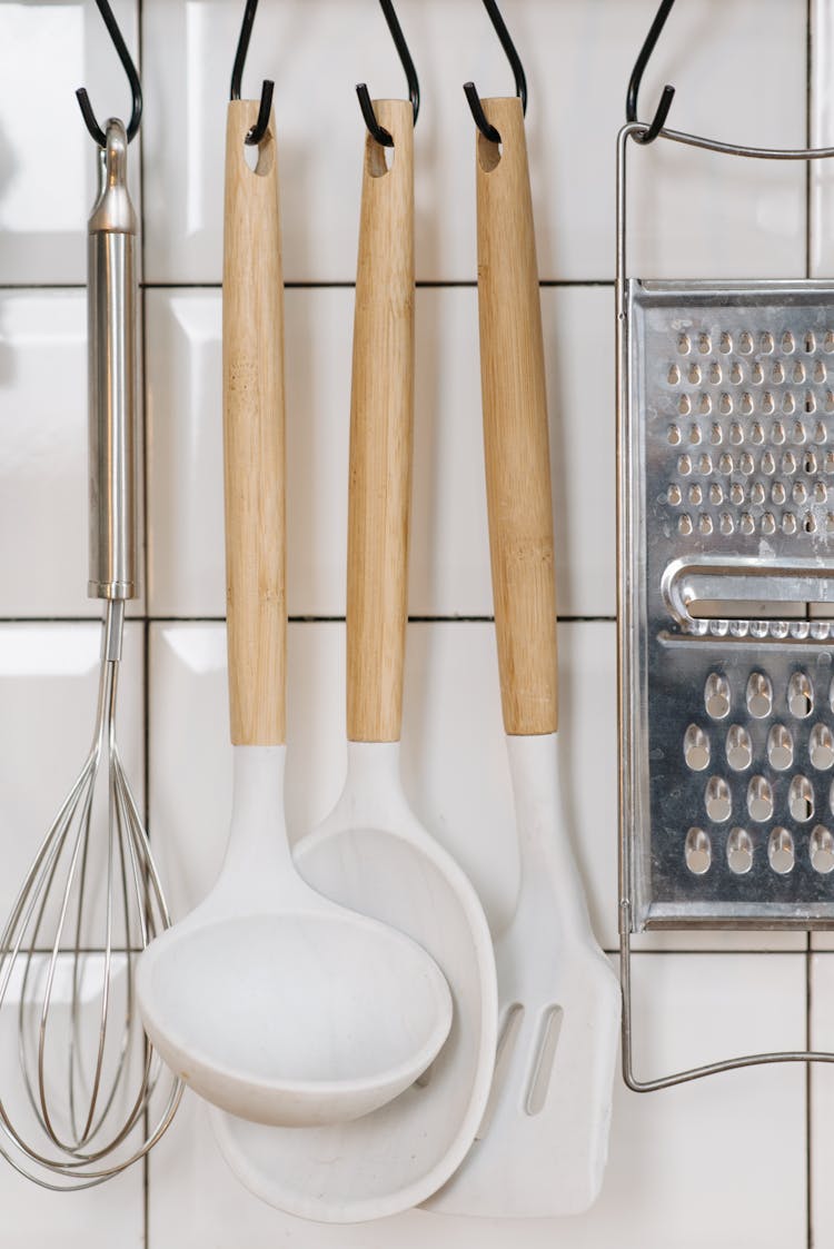 Wooden Spoons And Grater On White Wall