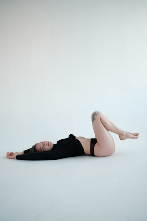 Calm fit female in panties lying on floor gracefully