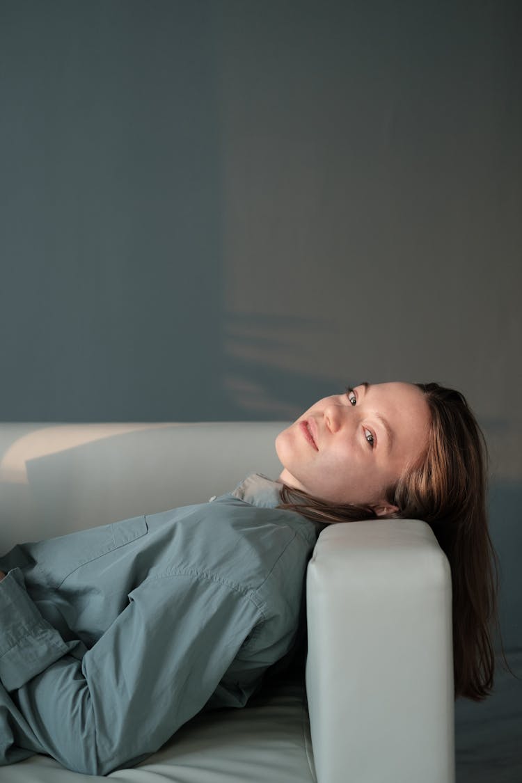 Lazy Woman Lying On Sofa In Sunlight