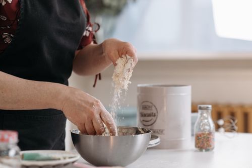 Free Close-up of hands mixing flour in a metal bowl for baking preparation. Stock Photo