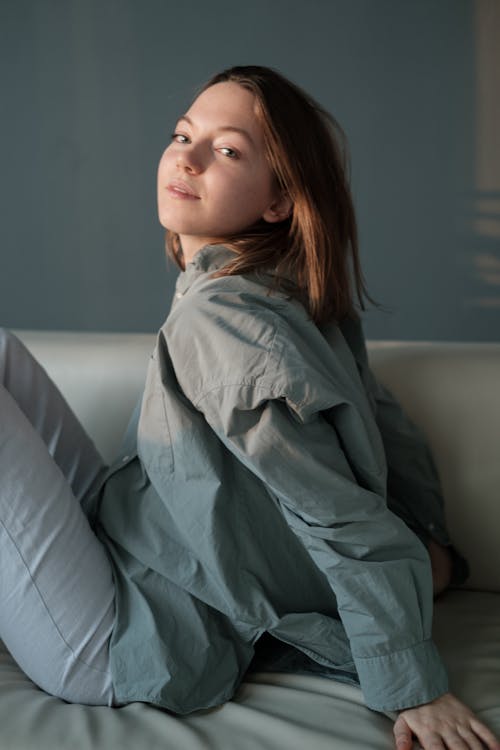 Free Gentle female sitting on couch at home Stock Photo