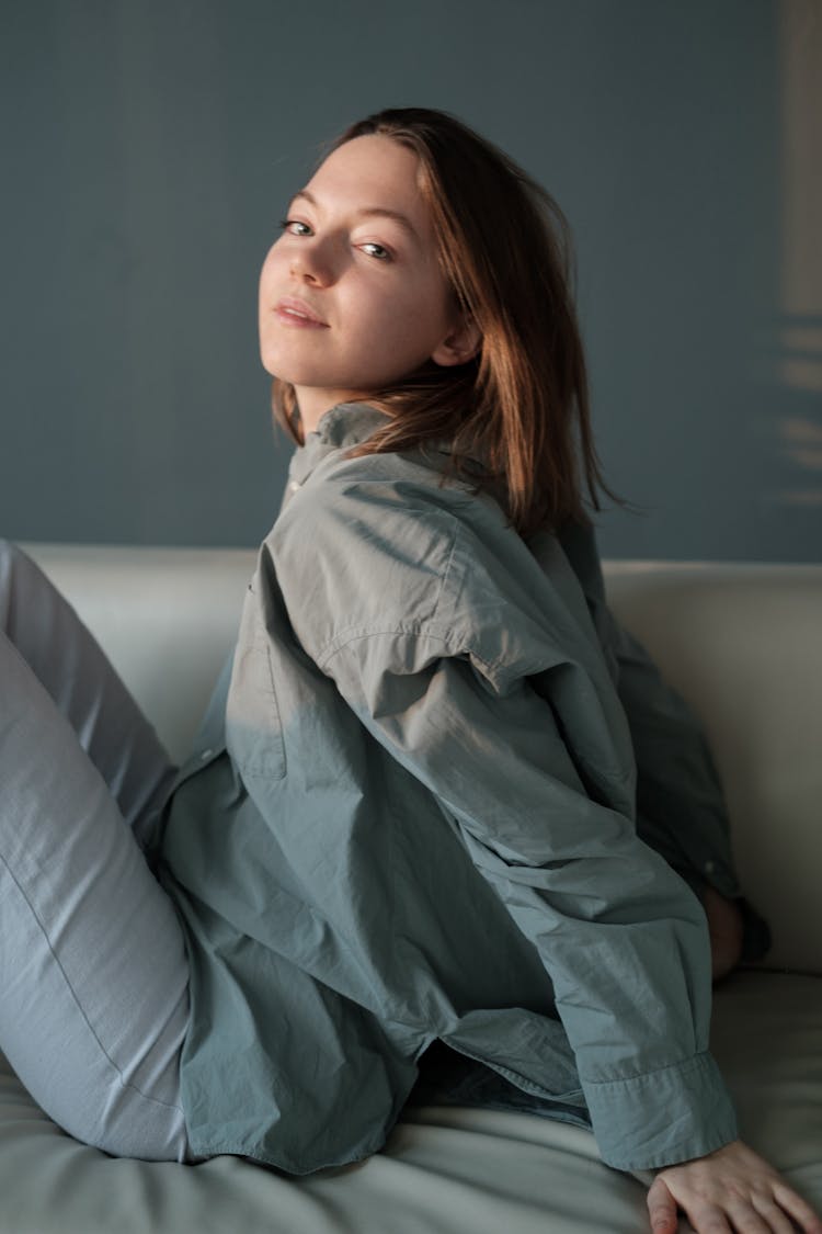 Gentle Female Sitting On Couch At Home