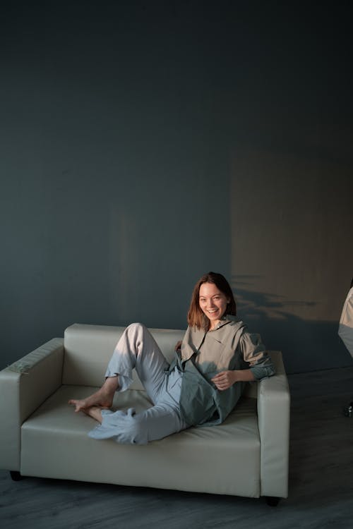 Free Positive woman resting on sofa in flat Stock Photo