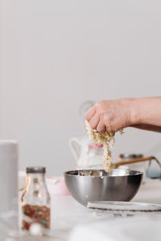 Hand kneading dough in a metal bowl, capturing the essence of homemade baking.
