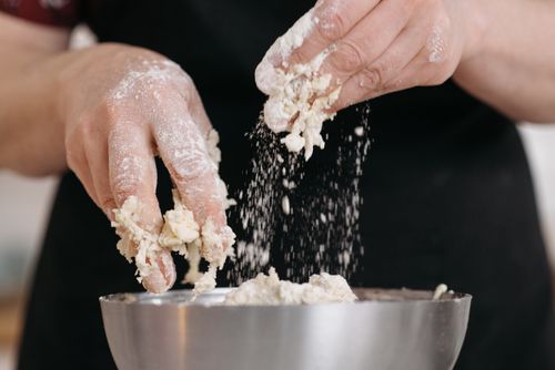 Free Close-up of hands kneading dough with flour in a stainless steel bowl, perfect for food preparation visuals. Stock Photo