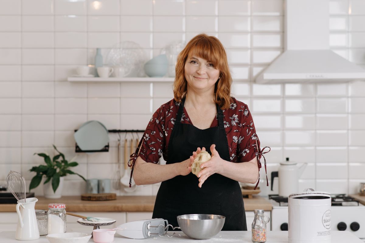 A woman kneading dough on a floured kitchen counter