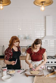 A mother and daughter bond while baking in a cozy kitchen setting, sharing a joyful cooking moment.