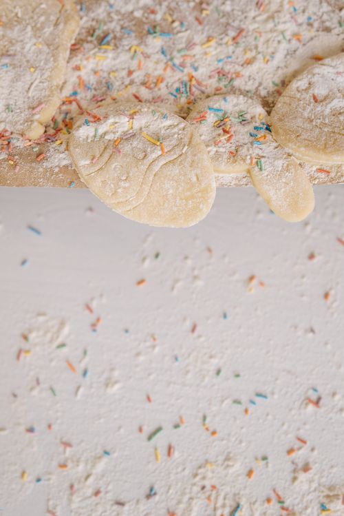 Free Delightful homemade cookies dough sprinkled with colorful toppings on a textured surface. Stock Photo