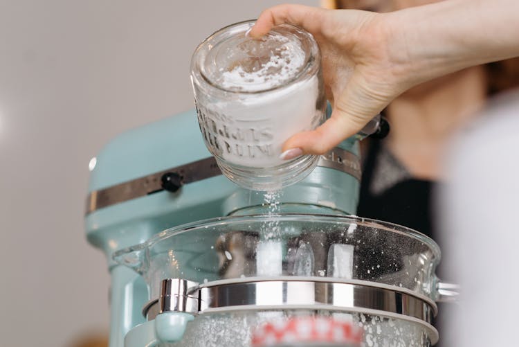 Person Pouring Flour On A Mixer