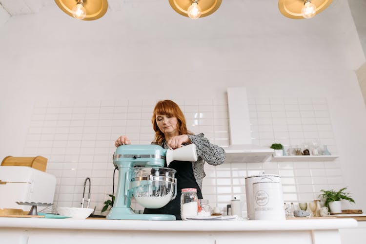 A Woman Pouring Milk In A Bowl