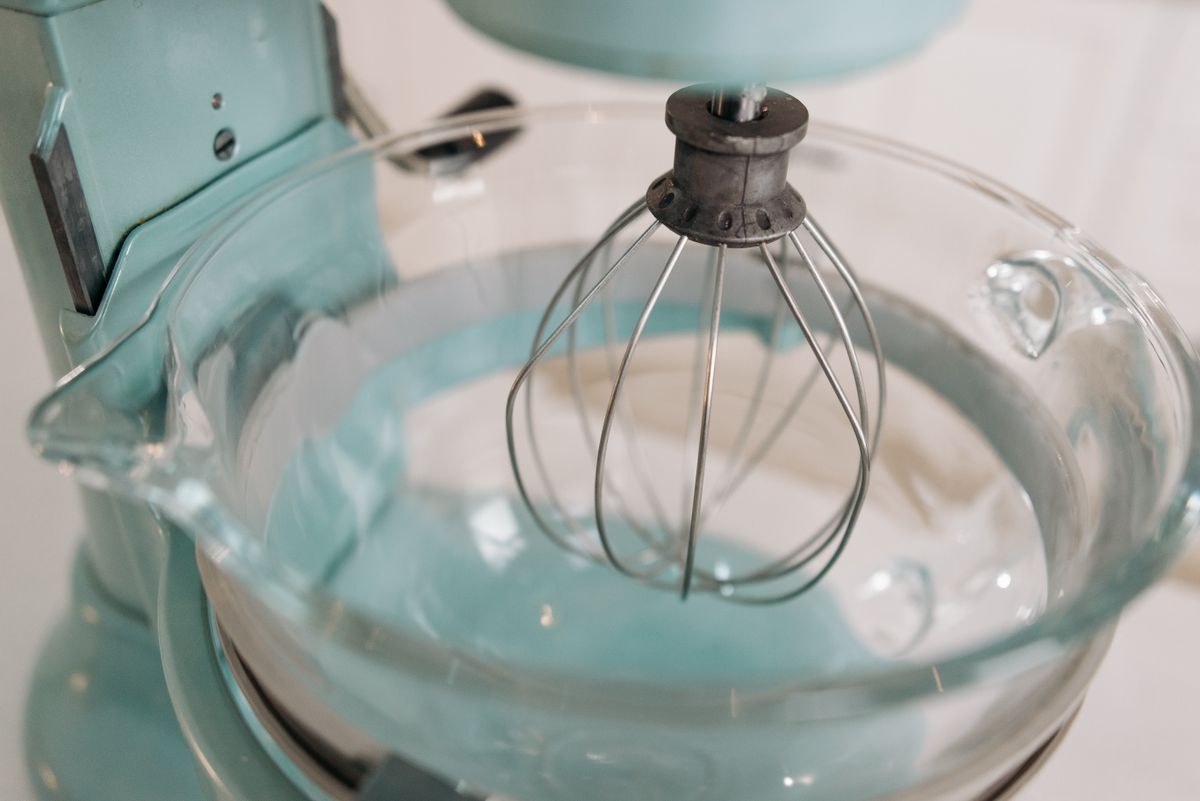 Close-up of a stand mixer's whisk attachment and glass bowl