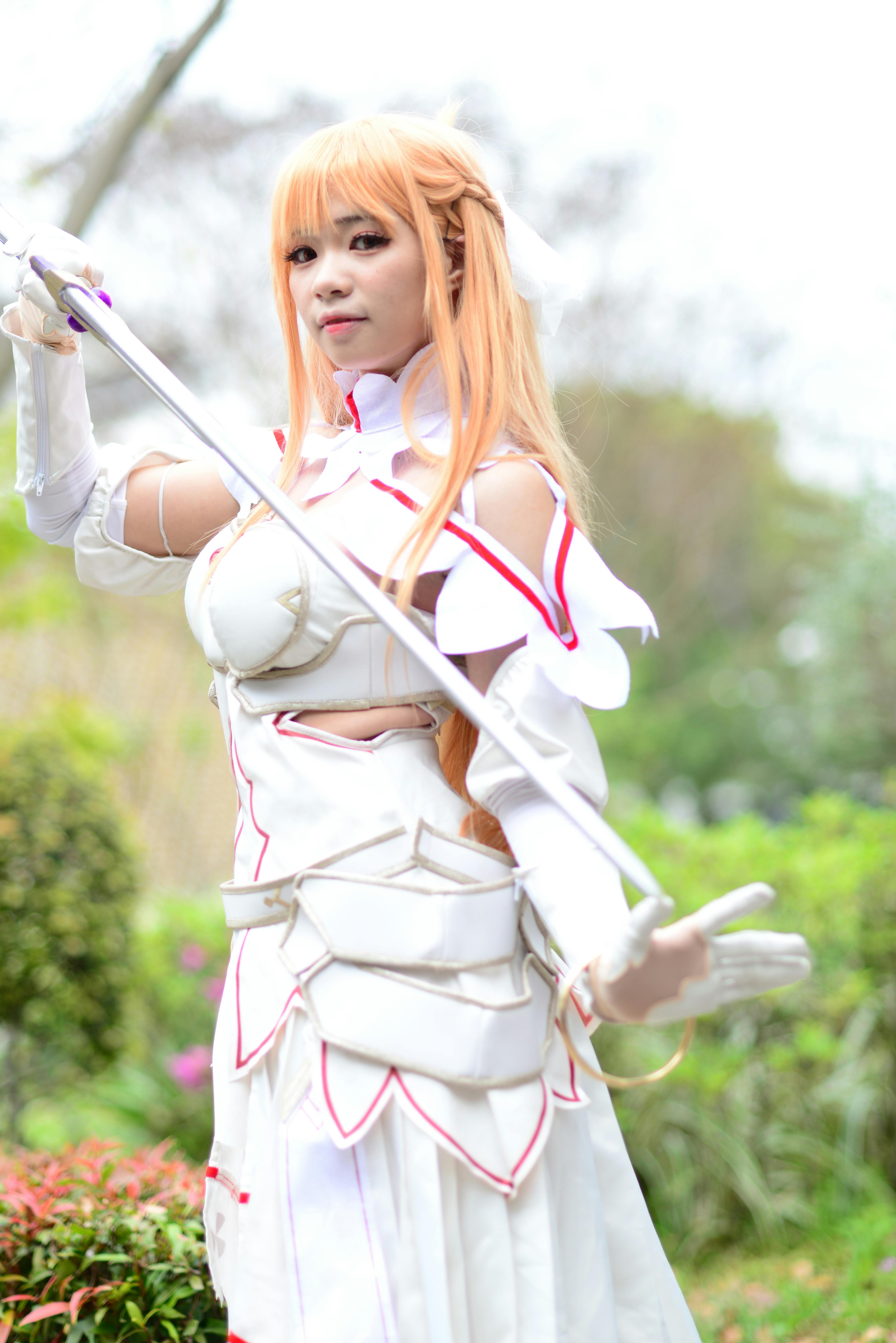 woman in white long sleeve dress holding a sword