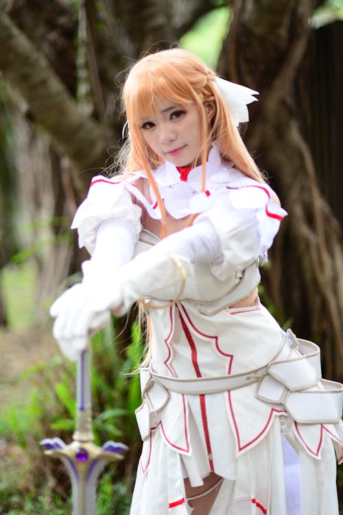 Woman in White Long Sleeve Dress Leaning on Sword