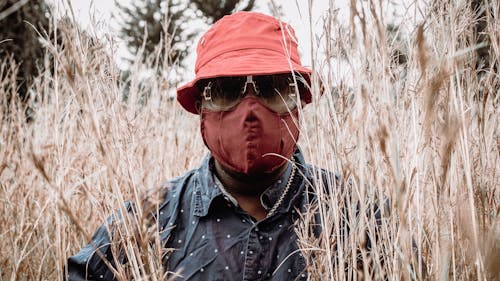 Free A Man Wearing Bucket Hat and a Face Mask on a Field Stock Photo