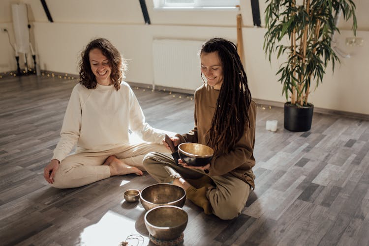 A Woman Holding A Tibetan Singing Bowl And A Mallet