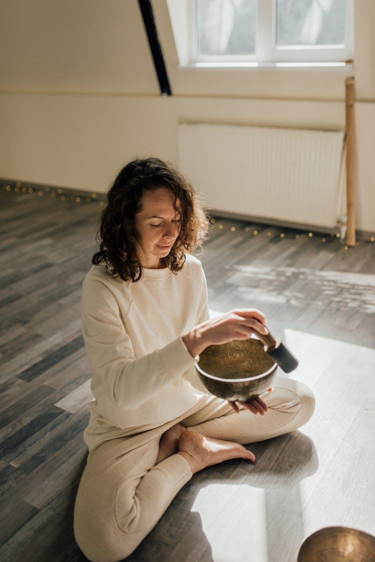 A Woman Using A Mallet And A Singing Bowl