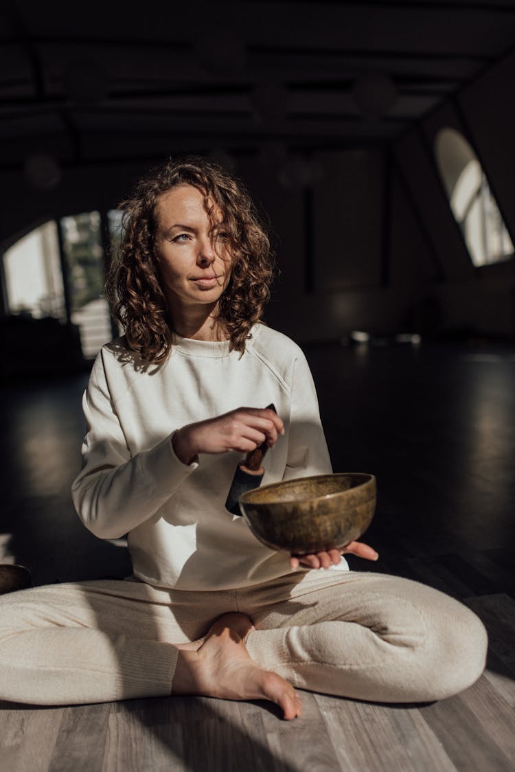 A Woman With A Mallet And Singing Bowl