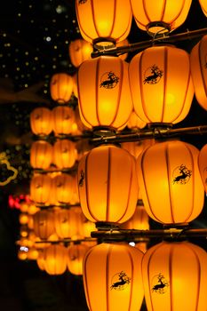 A row of glowing orange lanterns casts a warm, festive glow at night.