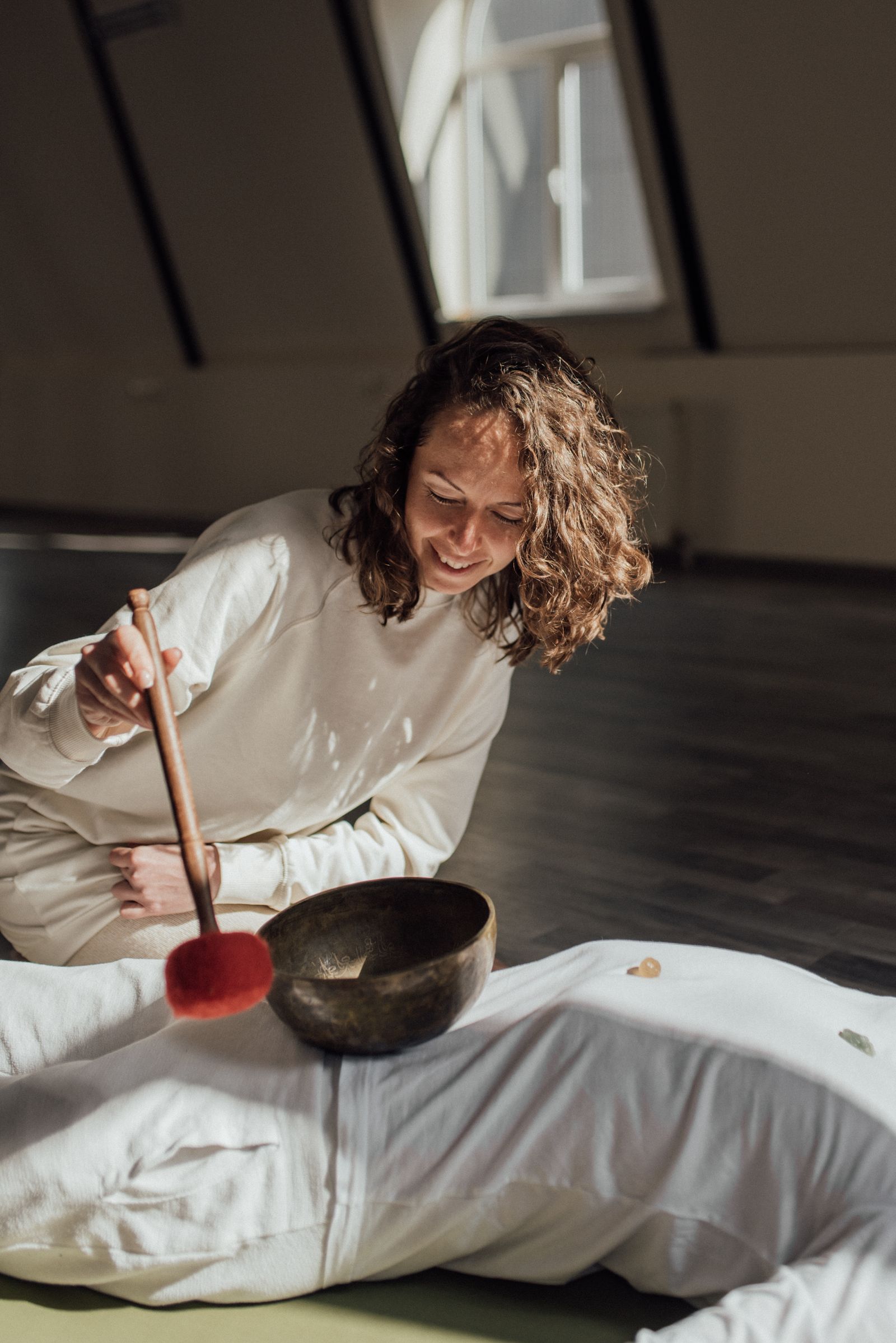 Practitioner giving a one-to-one singing bowl treatment