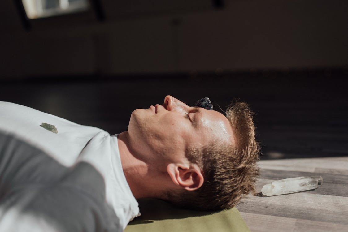 Free A Man Lying on Floor with Healing Crystals Stock Photo