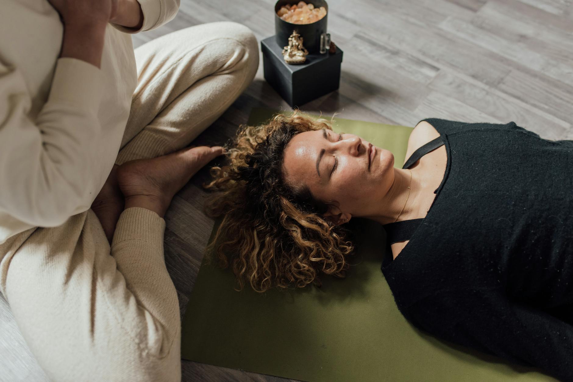A woman meditating indoors on a yoga mat in a calm atmosphere.