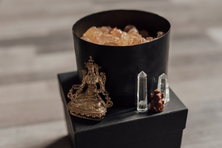 Tara Statue And Healing Crystals On Black Container