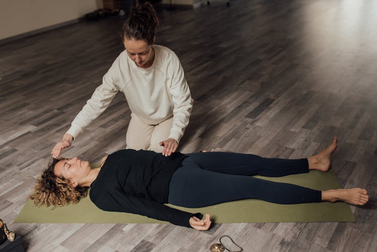 Energy Practitioner Healing Relaxed Woman On Yoga Mat