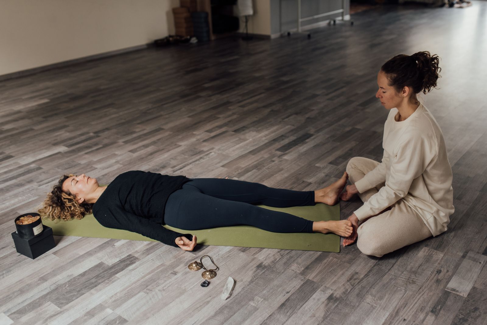 Two women practicing calming restorative stretches together indoors