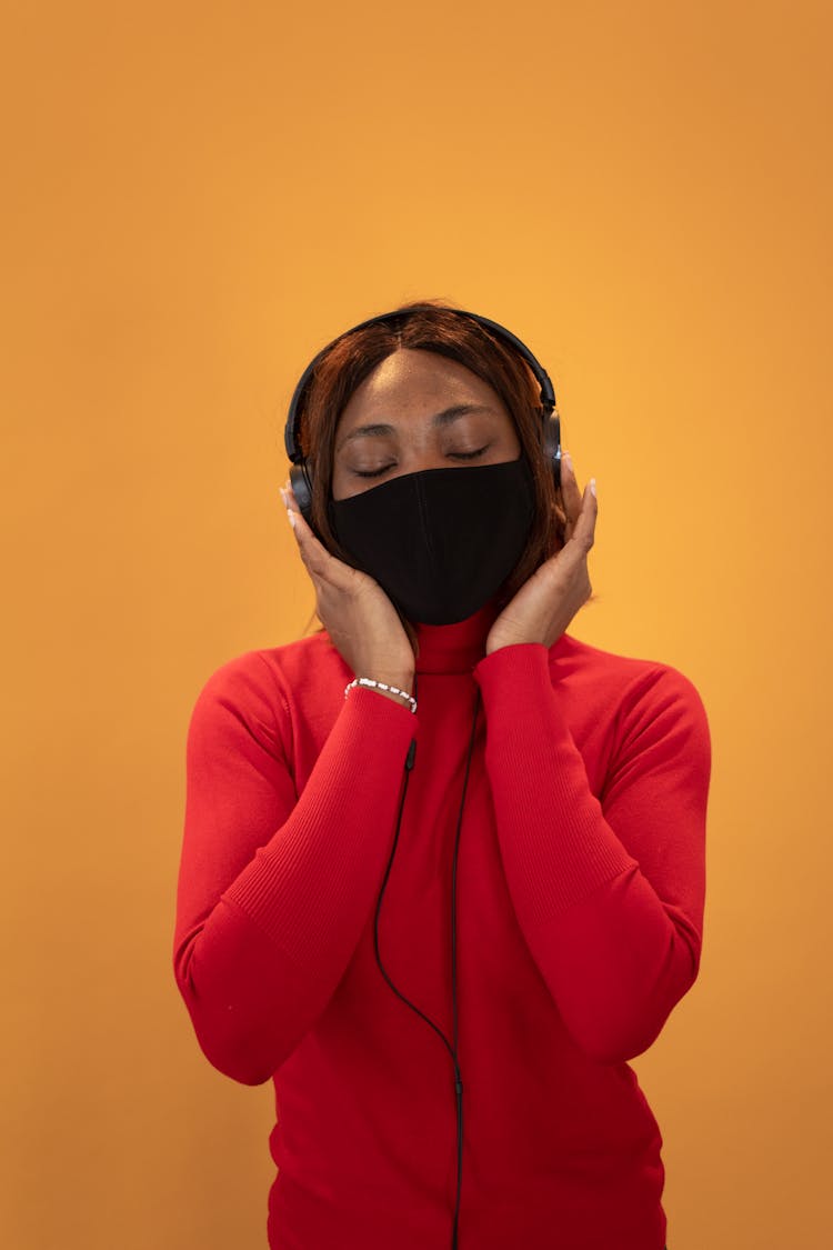 Black Woman In Medical Mask With Headphones