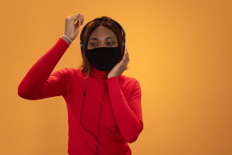 Black Woman In Face Mask Listening To Music