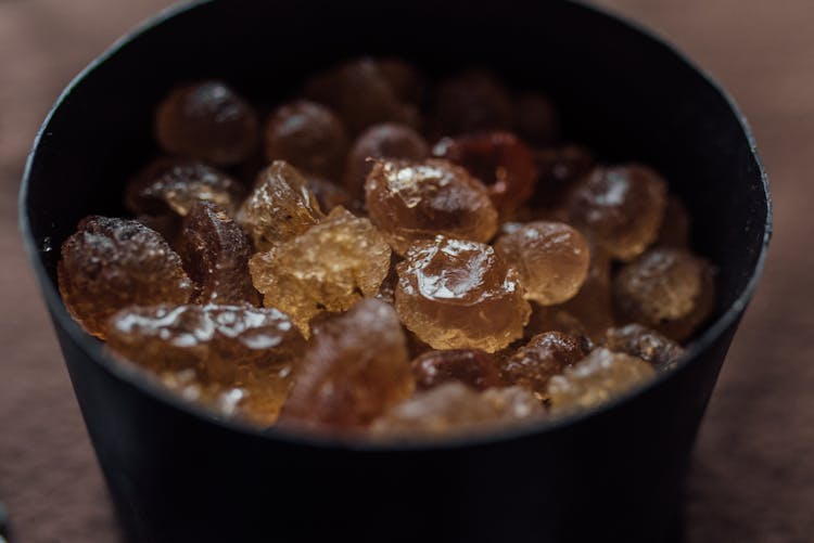 A Black Round Container With Candies