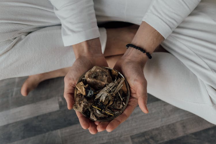 A Person Holding Healing Stones And Incense