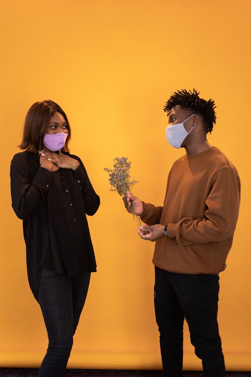Free Black man presenting flowers to young girlfriend Stock Photo