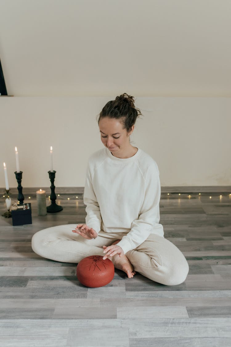 Woman Sitting On The Floor While Drumming