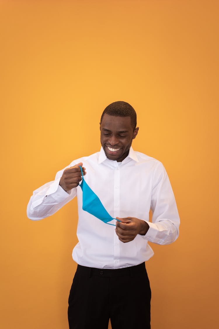 Smiling Black Man Wearing Mask Against Yellow Background