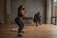Black sportspeople in fabric masks working out in gym