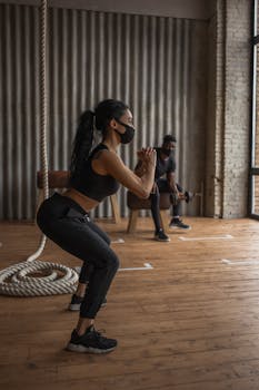 African American athletes exercising indoors with masks for safety during pandemic.